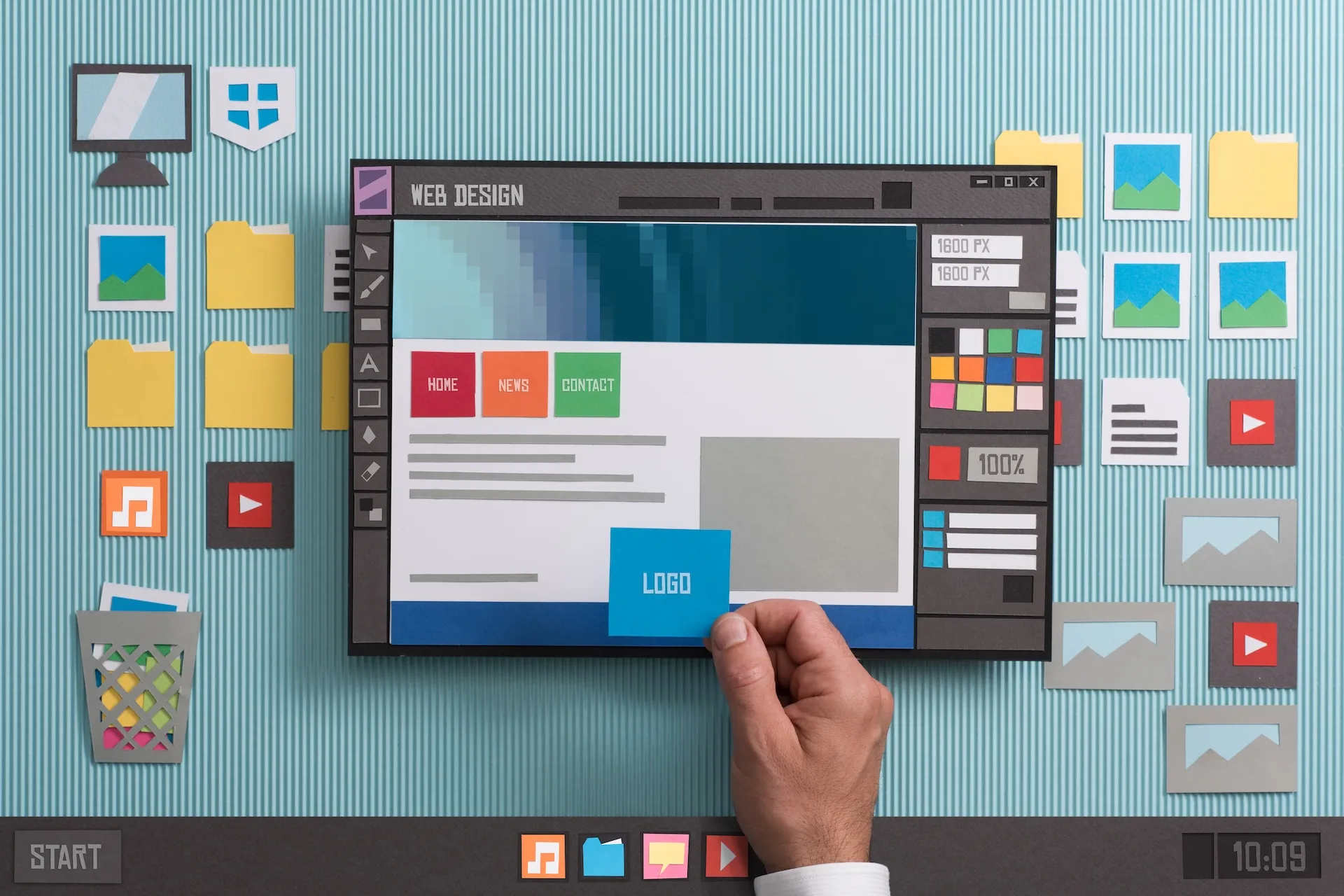 A hand arranges paper cutouts representing a web design interface for websites for bookkeepers, with navigation buttons, content areas, and editing tools on a blue background.